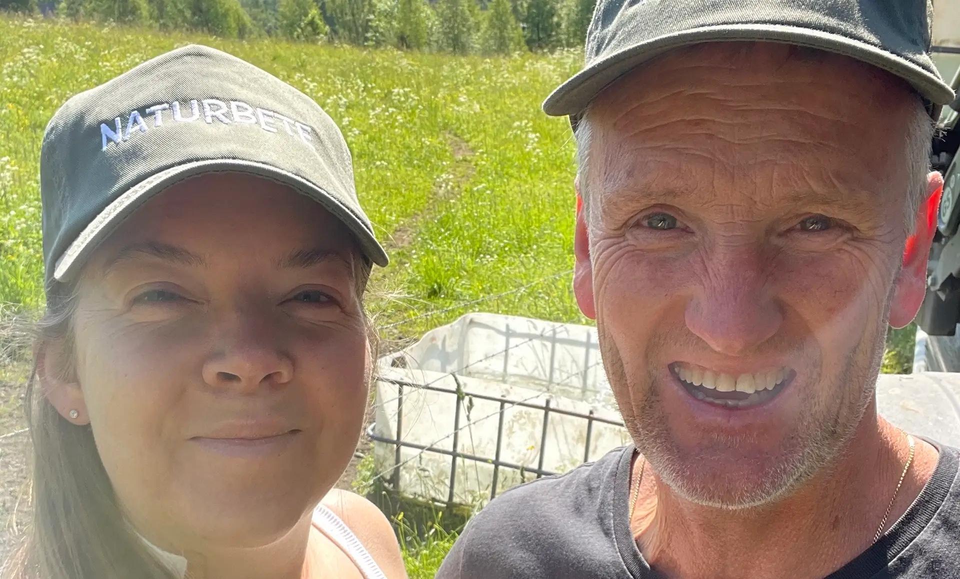 Två lantbrukare med kepsar märkta "Naturbete" under Naturbetesdagen 2025, i grönskande sommarbete – engagemang för hållbar betesdrift och biologisk mångfald.
